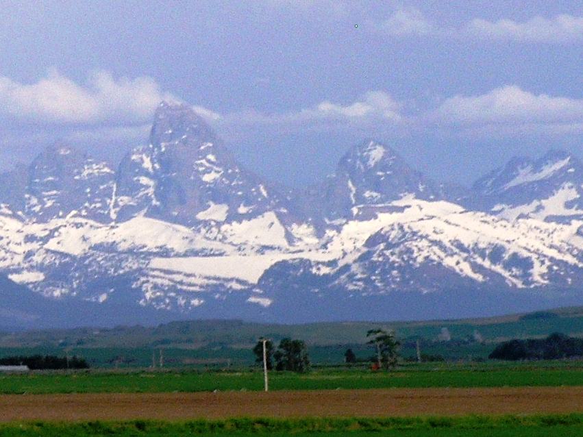The Teton peaks above green farmland, seen from the Idaho side